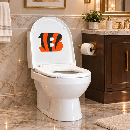 Cincinnati Bengals decorative sticker on the inside of a white toilet lid in a marble bathroom