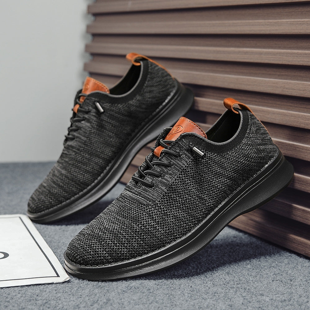 Men's breathable knit dress sneakers, black upper with black sole, angled pair view